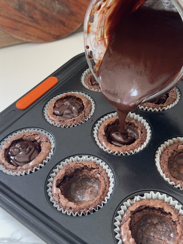 Pouring the ganache into the brownie cups