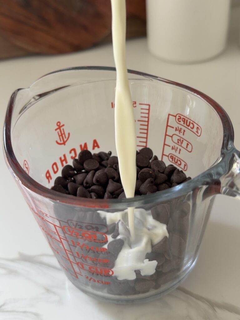 Pouring warm cream over chocolate chips