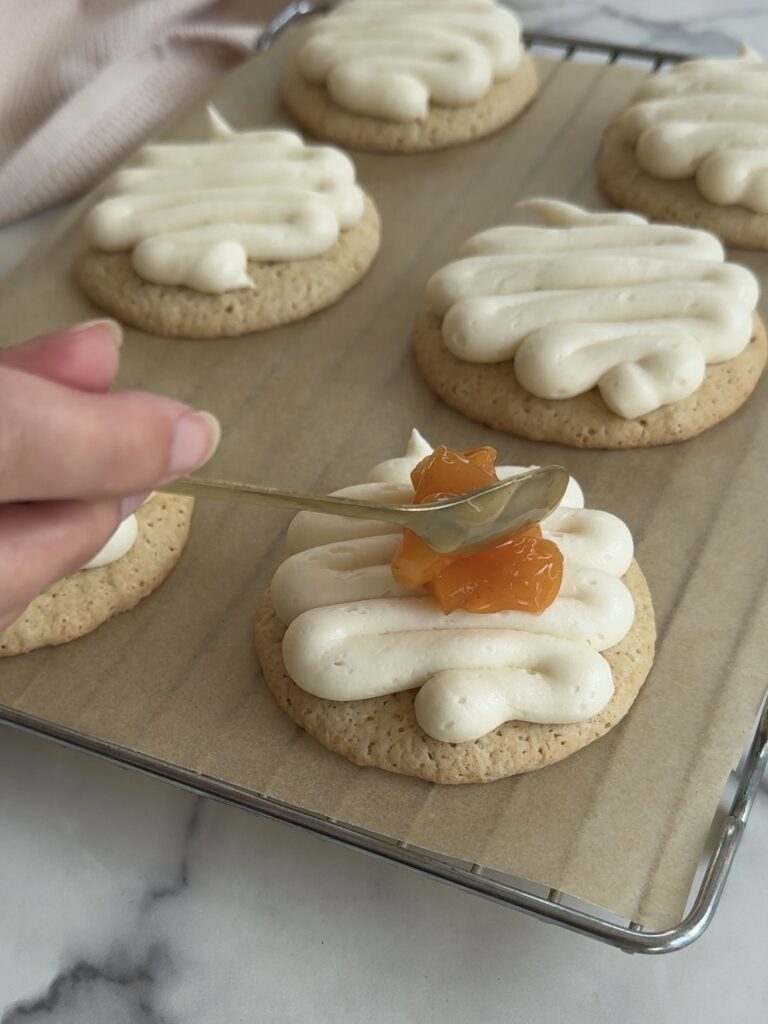 Topping the cookies with the cooked peaches